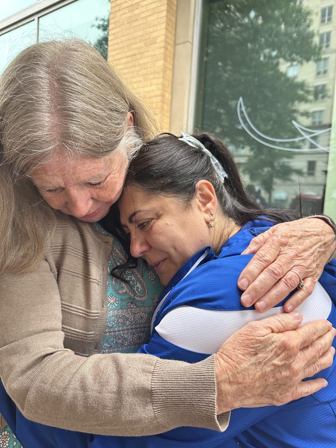 Two friends in an embrace outside the Ballstonian cart