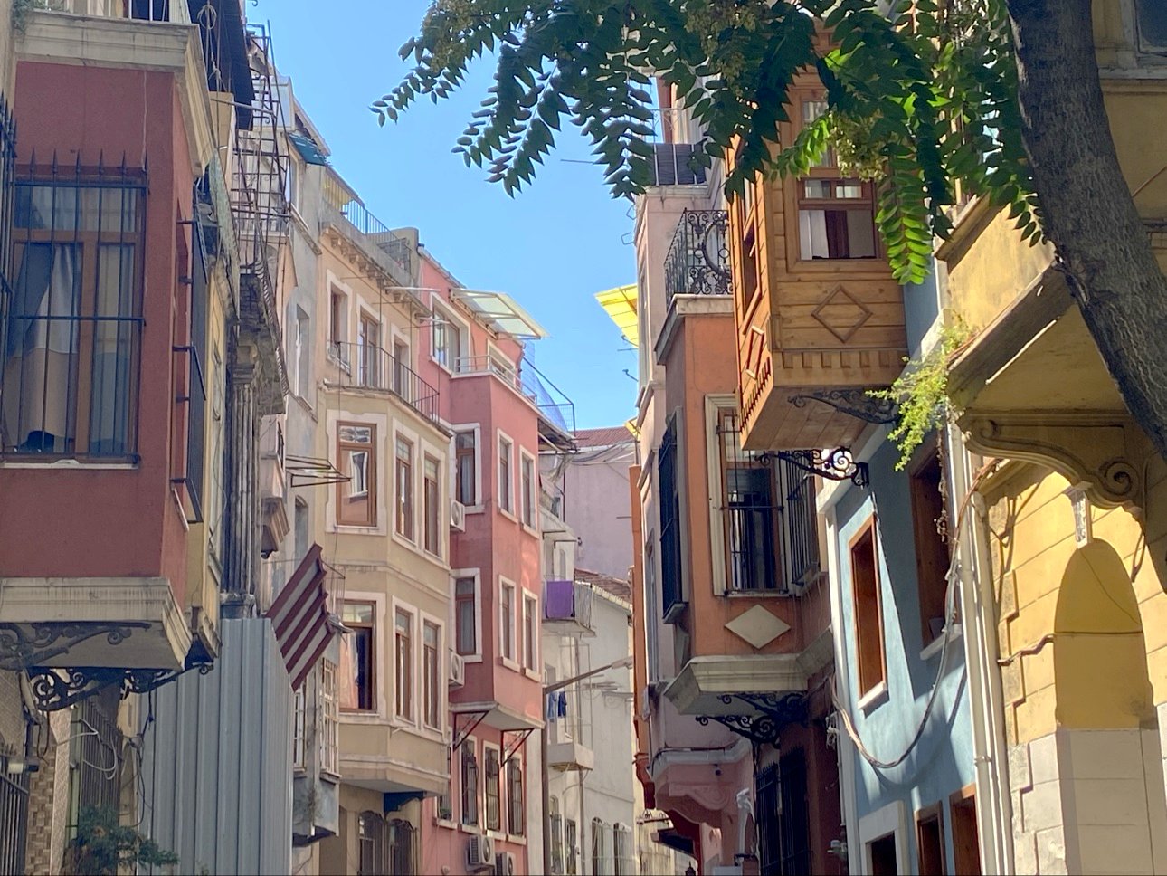 Old houses with painted bay windows leaning over a narrow street